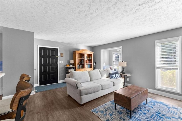 living room featuring a textured ceiling, plenty of natural light, and dark wood-type flooring