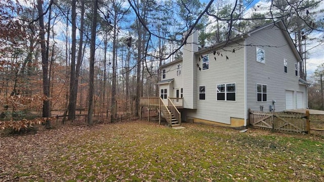 back of house with a garage and a lawn