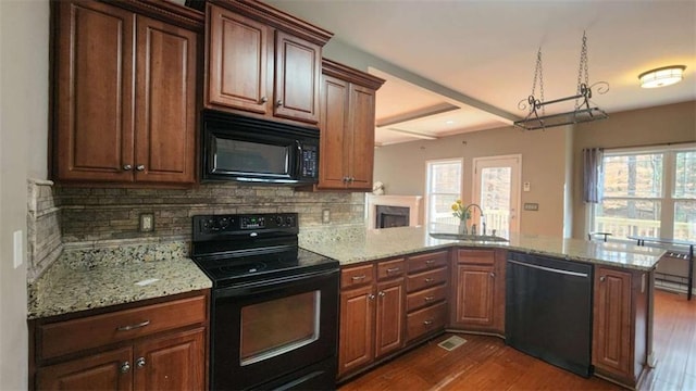 kitchen featuring sink, plenty of natural light, black appliances, and kitchen peninsula