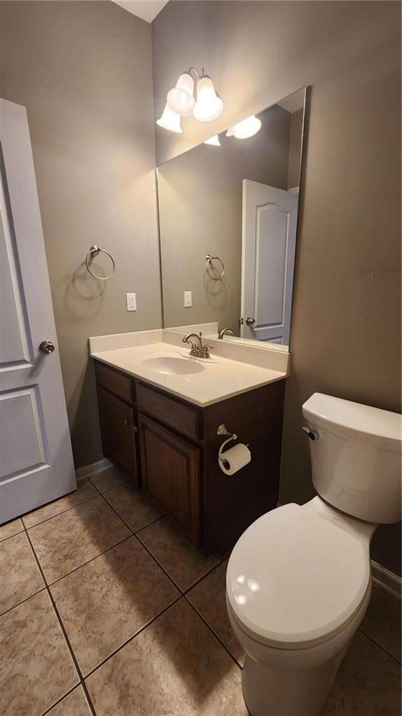 bathroom featuring vanity, toilet, and tile patterned flooring