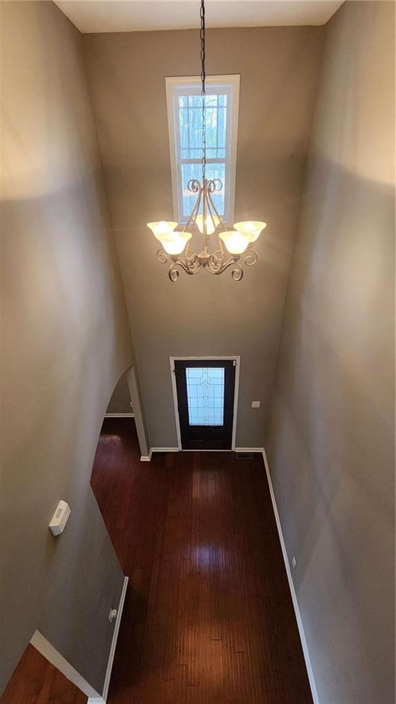 foyer entrance with dark hardwood / wood-style floors and a notable chandelier
