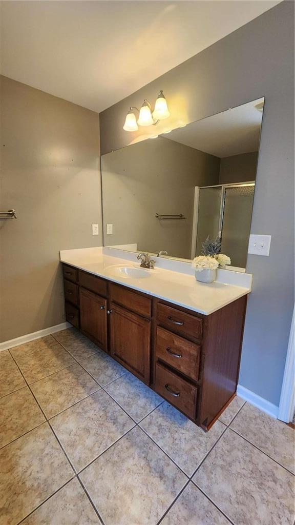 bathroom featuring tile patterned flooring, vanity, and walk in shower