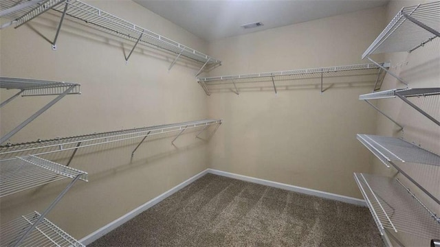 spacious closet with dark carpet