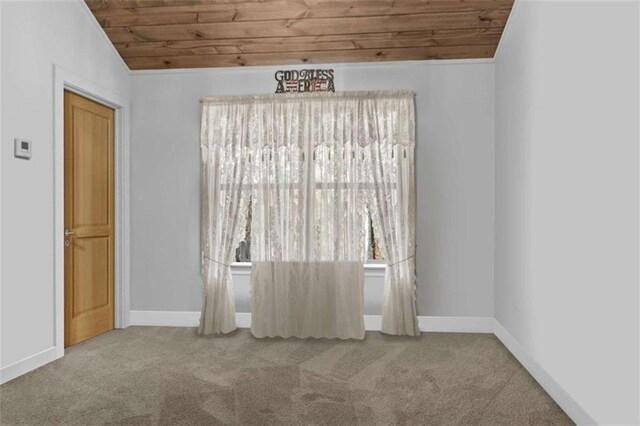 carpeted empty room with wooden ceiling, baseboards, and vaulted ceiling