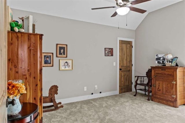 living area with vaulted ceiling, carpet flooring, baseboards, and ceiling fan