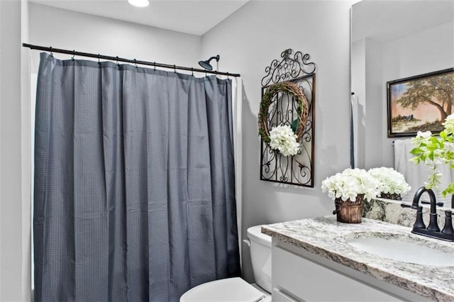 bathroom featuring toilet, curtained shower, and vanity