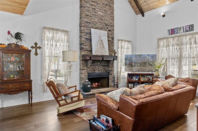 living area with high vaulted ceiling, a stone fireplace, wood ceiling, and wood finished floors