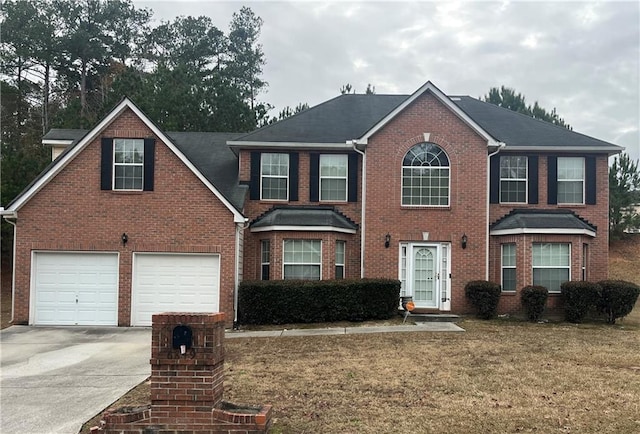 colonial home featuring a garage, driveway, and brick siding