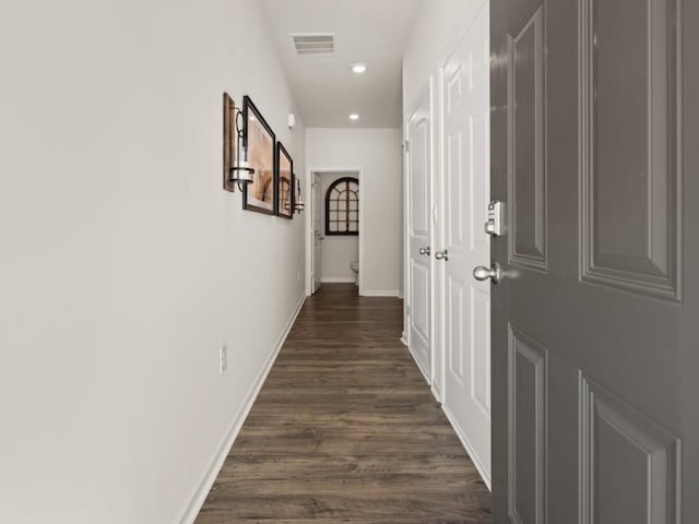 hallway with baseboards, visible vents, dark wood-style flooring, and recessed lighting