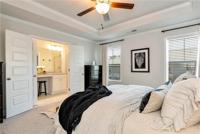 carpeted bedroom with a tray ceiling, ornamental molding, and ceiling fan