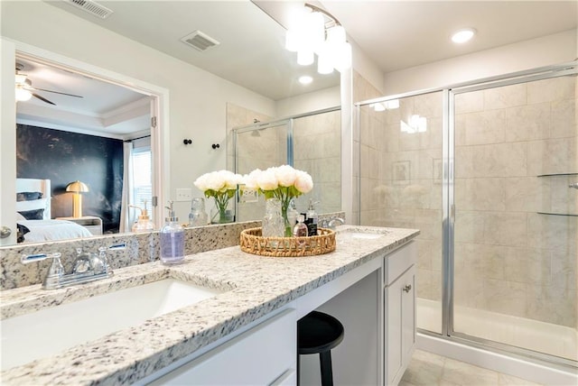 bathroom with ceiling fan, vanity, tile patterned flooring, and a shower with door