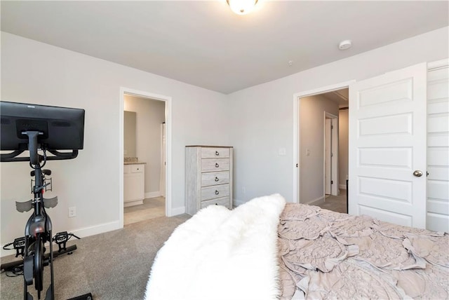 bedroom featuring connected bathroom and light colored carpet