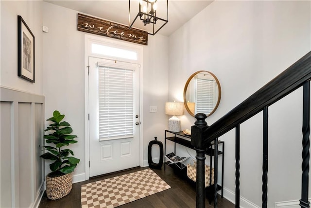 entrance foyer with dark hardwood / wood-style flooring and an inviting chandelier