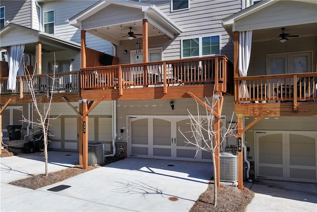 exterior space featuring a garage, cooling unit, and ceiling fan