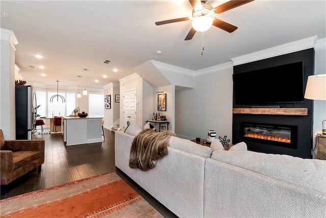 living room with ornamental molding, dark hardwood / wood-style floors, and ceiling fan