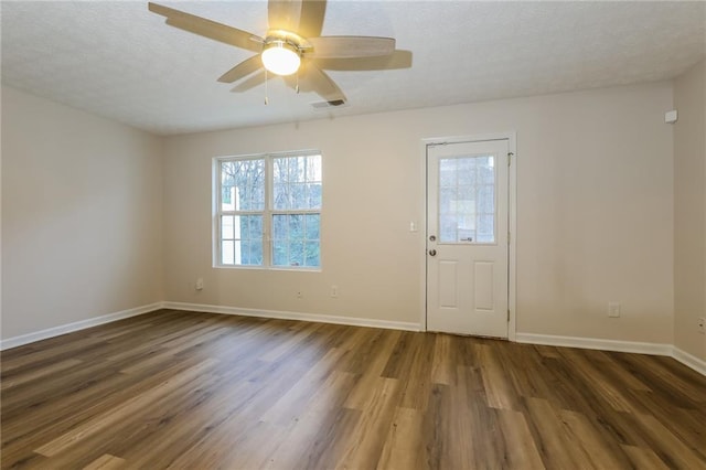 foyer entrance with a textured ceiling, ceiling fan, and dark wood-type flooring