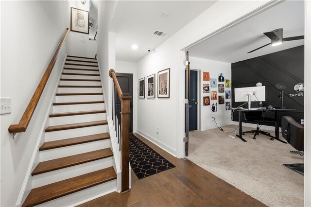 stairway with hardwood / wood-style flooring and ceiling fan