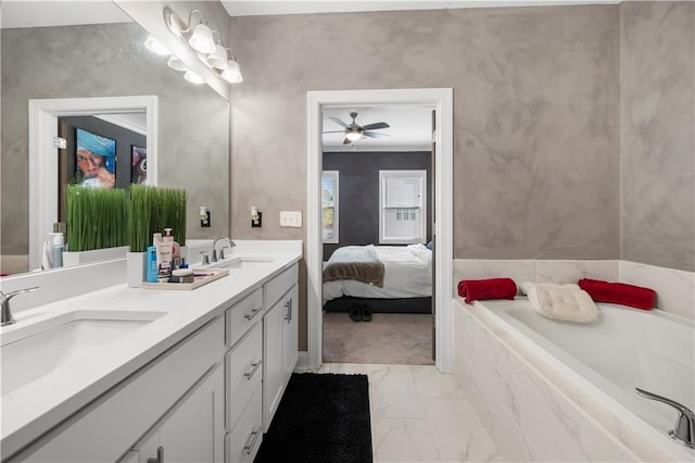 bathroom with tiled tub, ceiling fan, and vanity