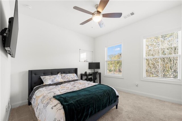 carpeted bedroom with multiple windows and ceiling fan