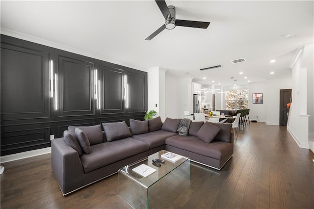 living room featuring dark hardwood / wood-style flooring, ceiling fan, and crown molding