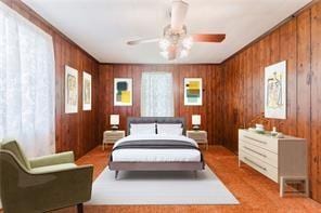 bedroom with ornamental molding, wood walls, and ceiling fan