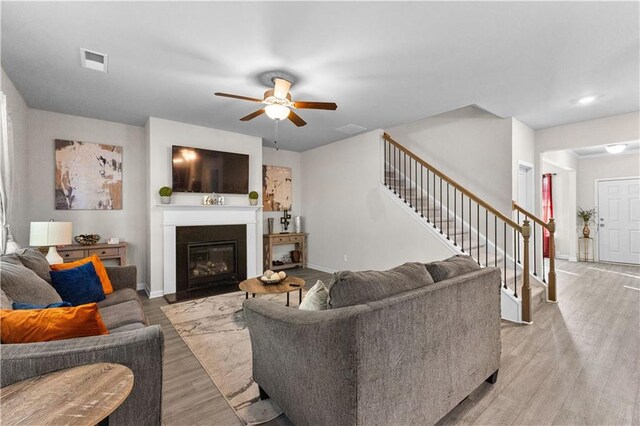 living room with light hardwood / wood-style floors and ceiling fan