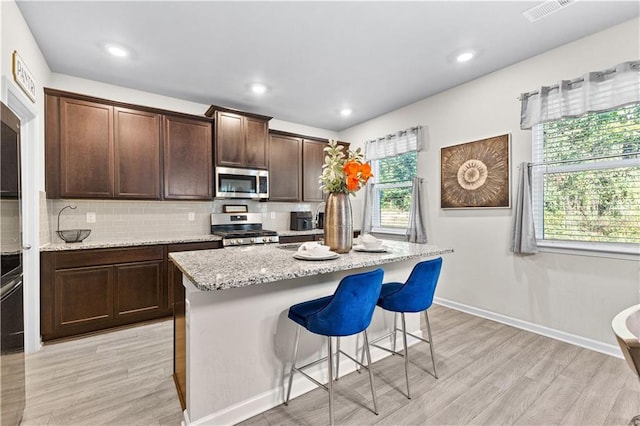 kitchen with plenty of natural light, an island with sink, and appliances with stainless steel finishes