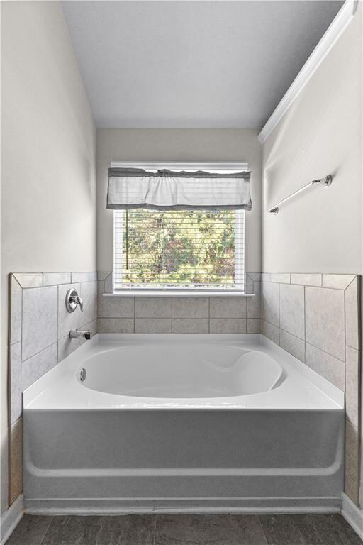 bathroom featuring tile patterned flooring and a bath