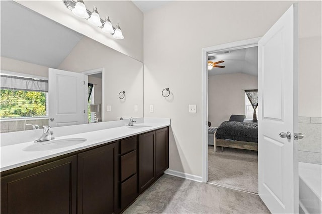 bathroom with ceiling fan, tile patterned flooring, vanity, and lofted ceiling