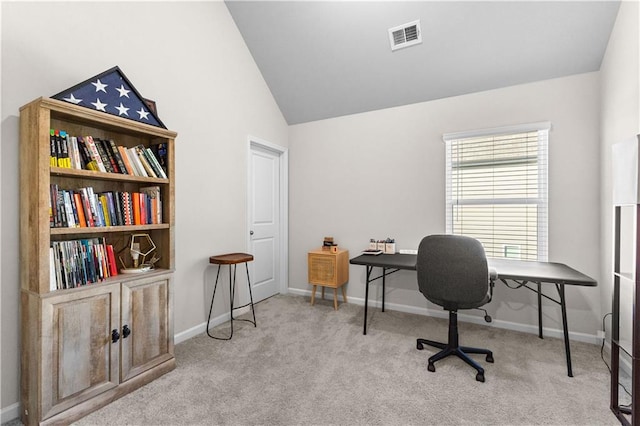 carpeted home office with vaulted ceiling