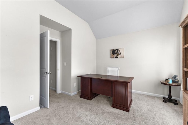 unfurnished office featuring lofted ceiling and light carpet