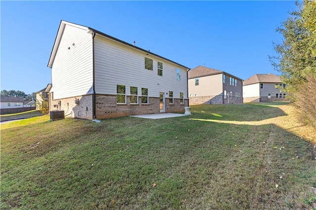 back of house featuring a lawn, central AC unit, and a patio area