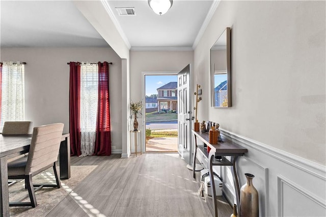 entryway featuring light hardwood / wood-style floors and crown molding