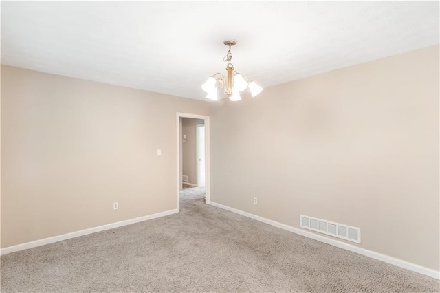 empty room with baseboards, light carpet, a chandelier, and visible vents
