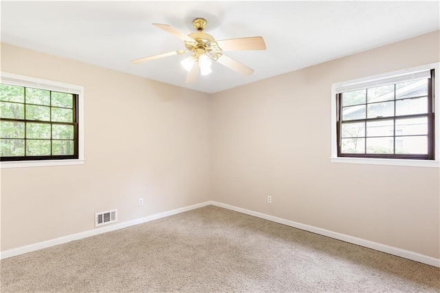 unfurnished room featuring baseboards, visible vents, and a wealth of natural light