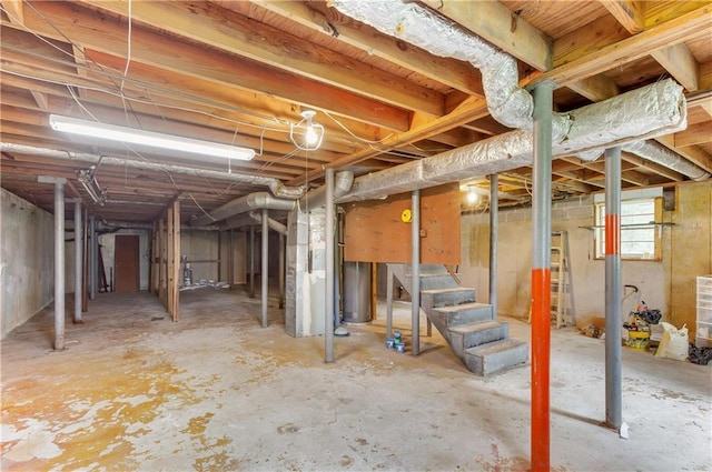basement featuring stairs and gas water heater