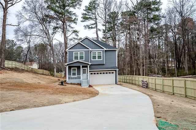 view of front of property with board and batten siding, concrete driveway, fence, and a garage