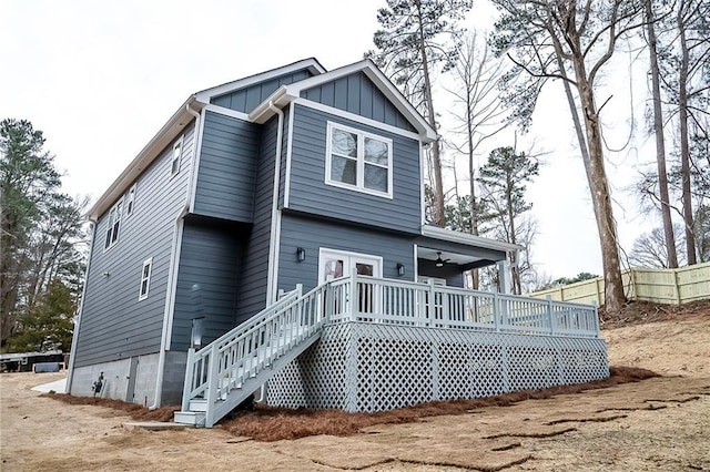 back of house with a deck, stairway, board and batten siding, and fence