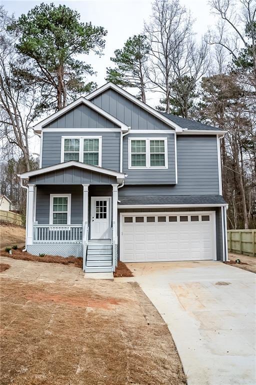 traditional home featuring a garage, a porch, board and batten siding, and concrete driveway