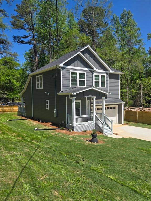 113 Miller Rd, Stockbridge, GA 30281 - view of front facade with fence, board and batten siding, driveway, covered porch, and a garage