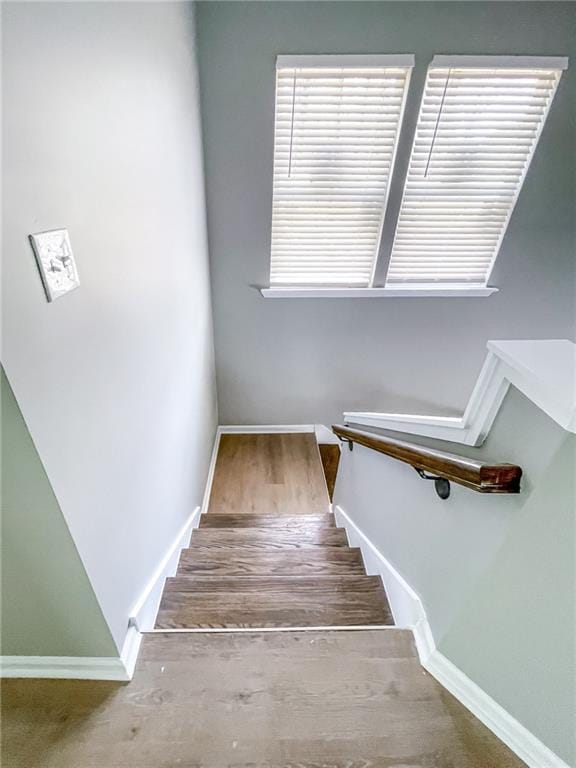 staircase with baseboards and wood finished floors