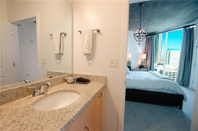 bathroom with ensuite bathroom, vanity, a chandelier, and floor to ceiling windows
