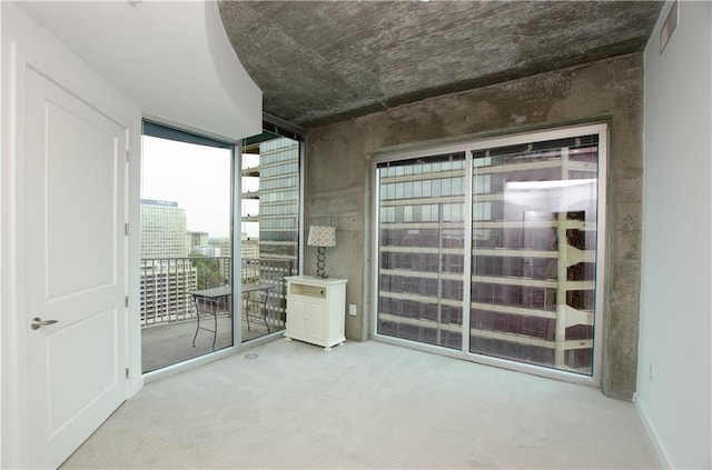 empty room featuring expansive windows and carpet flooring