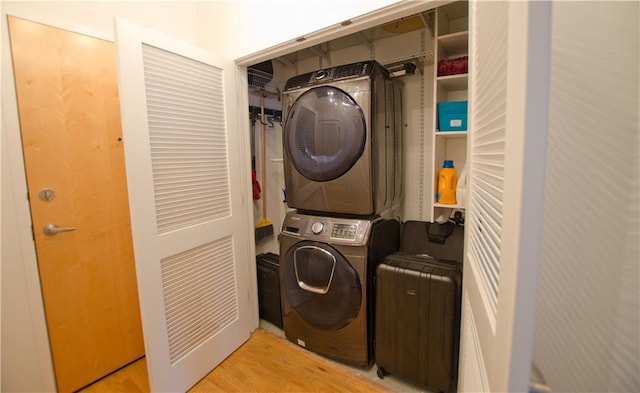 clothes washing area with stacked washer / dryer and wood finished floors