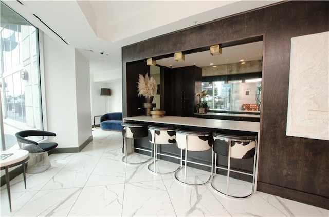 bar area featuring marble finish flooring and baseboards