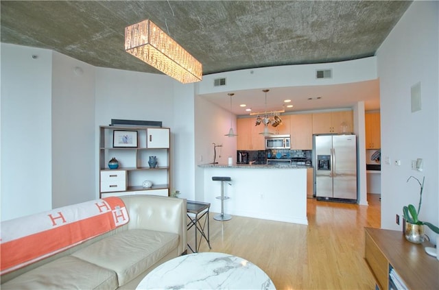 living room with a chandelier and light wood finished floors