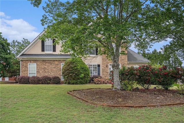 view of front of property with stucco siding, a front yard, and stone siding