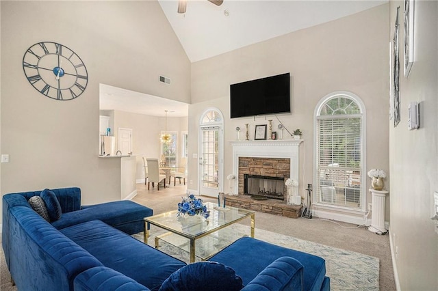carpeted living room featuring a fireplace, high vaulted ceiling, a ceiling fan, visible vents, and baseboards