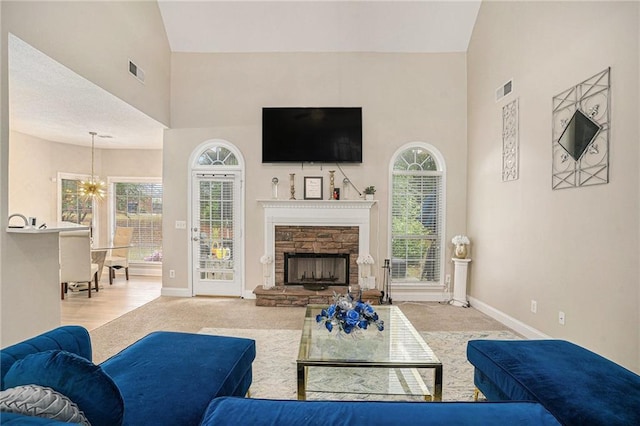 113 Glenmore Ln, Mcdonough, GA 30253 - carpeted living area featuring a high ceiling, baseboards, a chandelier, and a fireplace