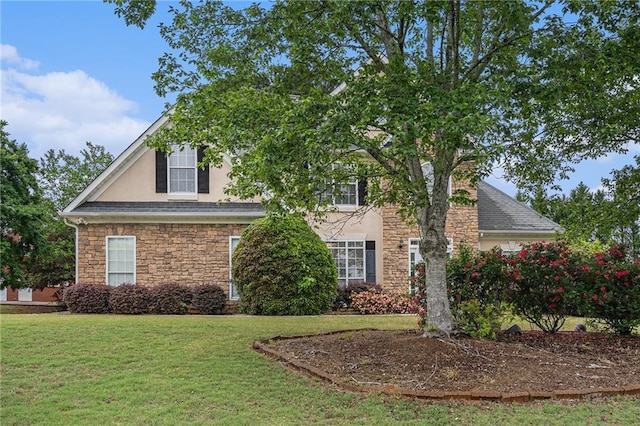 view of front facade with a front lawn, stone siding, and stucco siding